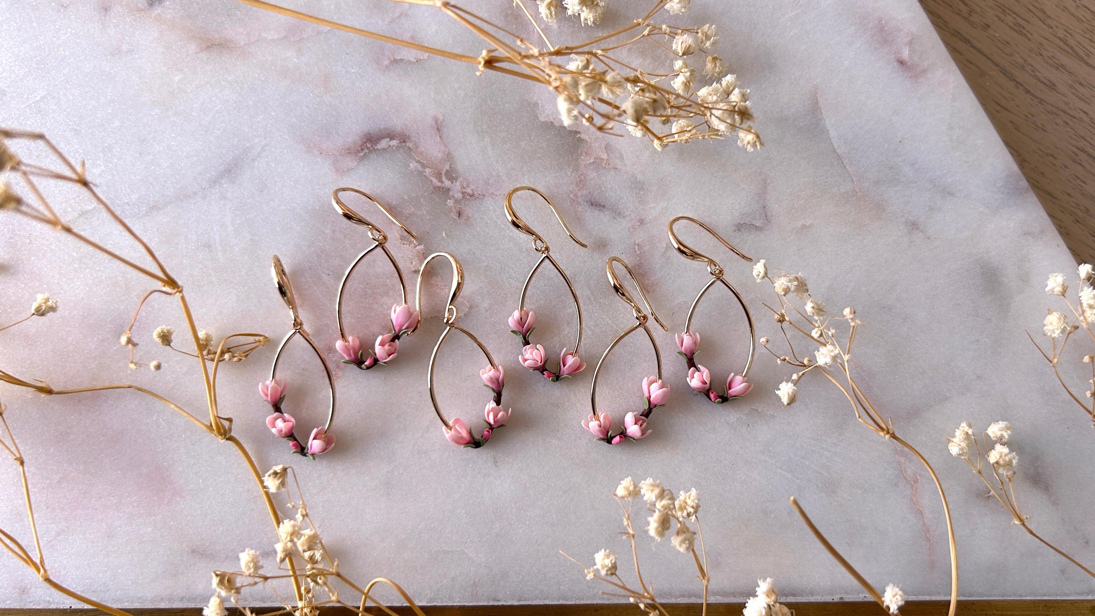 Oval shape drop earrings with pink magnolia flowers sculpted from polymer clay